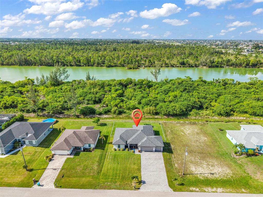 An aerial view shows a suburban house with a gray roof and a large backyard — 2926 NW 25TH STREET, CAPE CORAL, FL