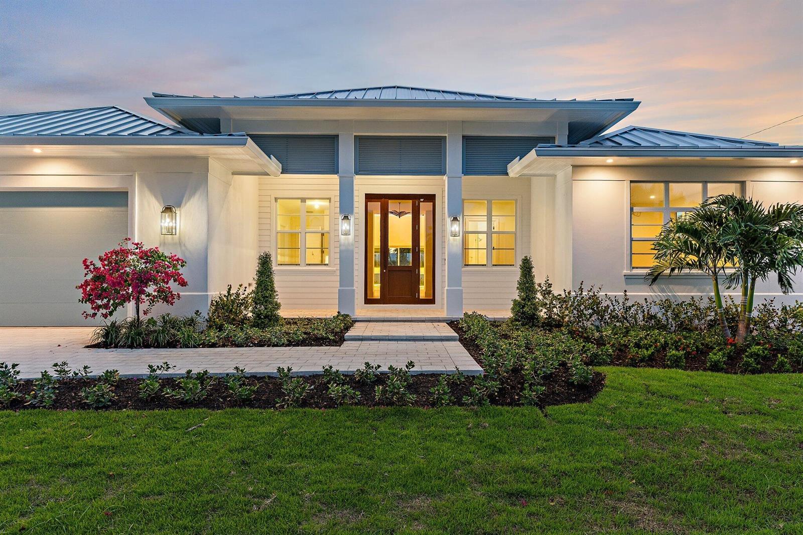 A modern single-story house with a metal roof, white exterior, and a paved walkway — 131 Dory Road S, North Palm Beach FL 33408, NORTH PALM BEACH, FL