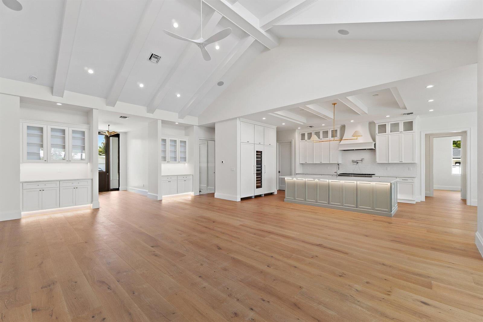 A bright, open-concept kitchen and living area features white cabinetry, a large island, and hardwood floors — 131 Dory Road S, North Palm Beach FL 33408, NORTH PALM BEACH, FL