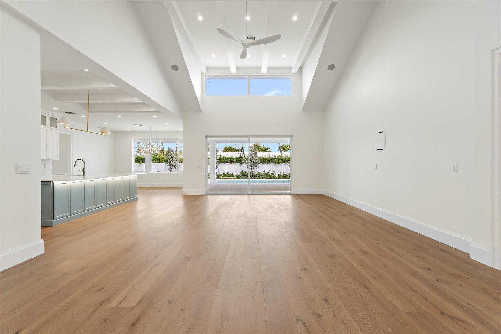 A bright, open-concept living area features vaulted ceilings, light wood floors, and a modern kitchen — 131 Dory Road S, North Palm Beach FL 33408, NORTH PALM BEACH, FL