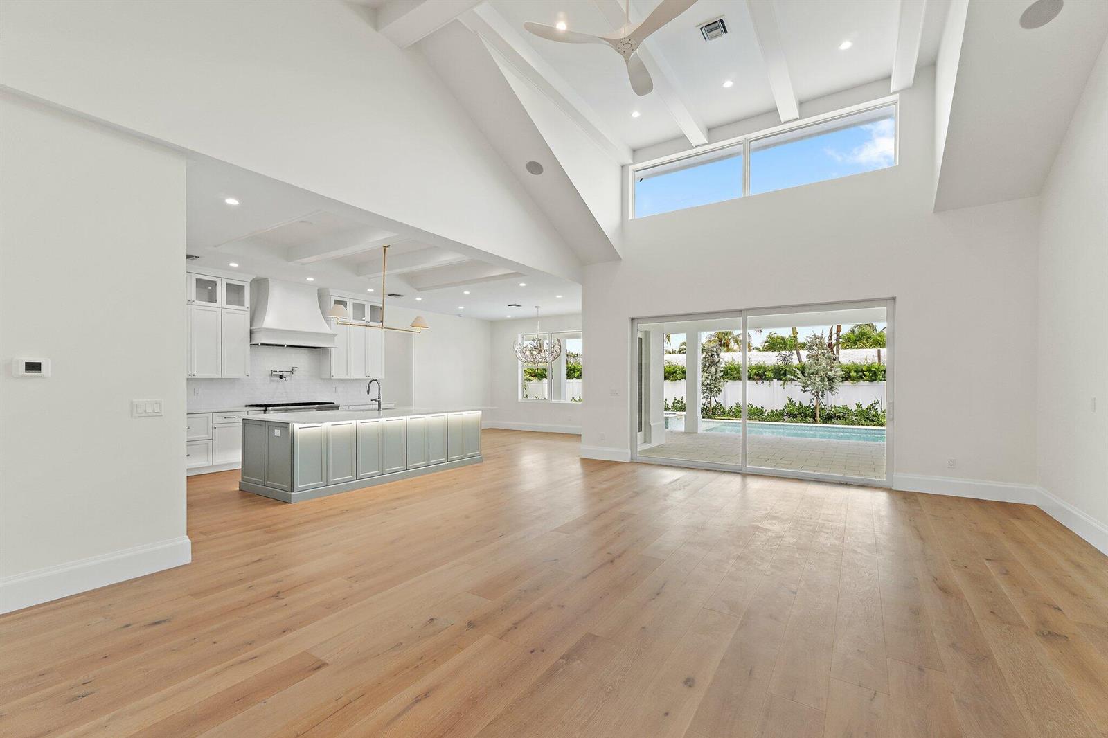 A spacious open-concept living area features a kitchen with a large island and vaulted ceilings — 131 Dory Road S, North Palm Beach FL 33408, NORTH PALM BEACH, FL