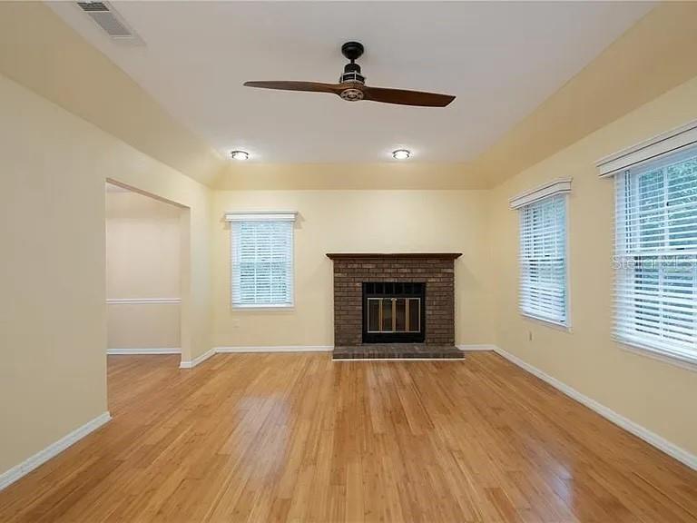 A living room with hardwood floors, a brick fireplace, and a ceiling fan — 5211 SW 86TH TERRACE, GAINESVILLE, FL