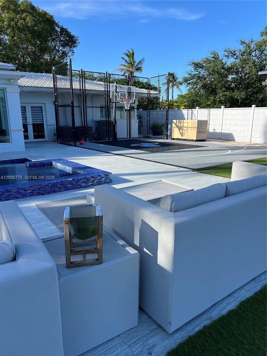 A backyard features a basketball court, a small swimming pool, and modern outdoor lounge furniture — 1100 NE 84th St, Miami FL 33138, MIAMI, FL
