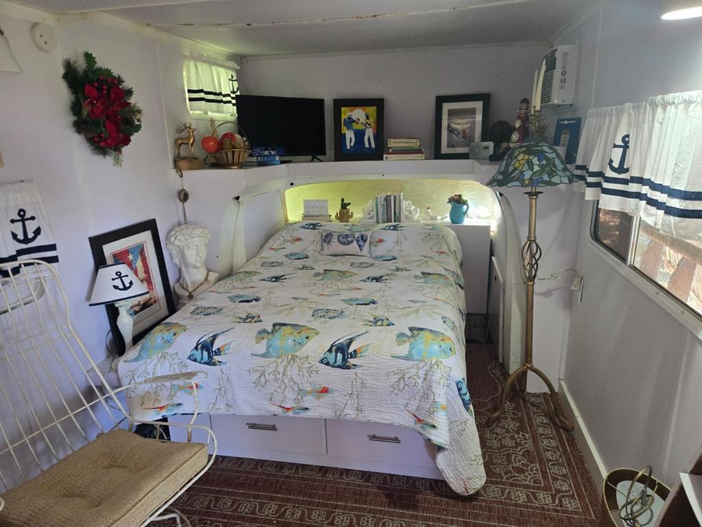 A bedroom in a camper features a bed with fish-patterned bedding and nautical decor — BO. LLANOS TUNA, SECTOR LAS MAGAS, CABO ROJO, PR