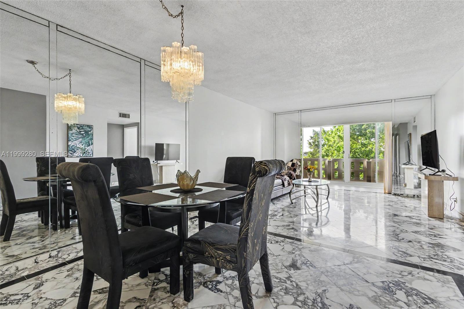 A dining and living area features marble floors, mirrored walls, and a glass-topped table — 4330 Hillcrest Dr # 405, Hollywood FL 33021, HOLLYWOOD, FL
