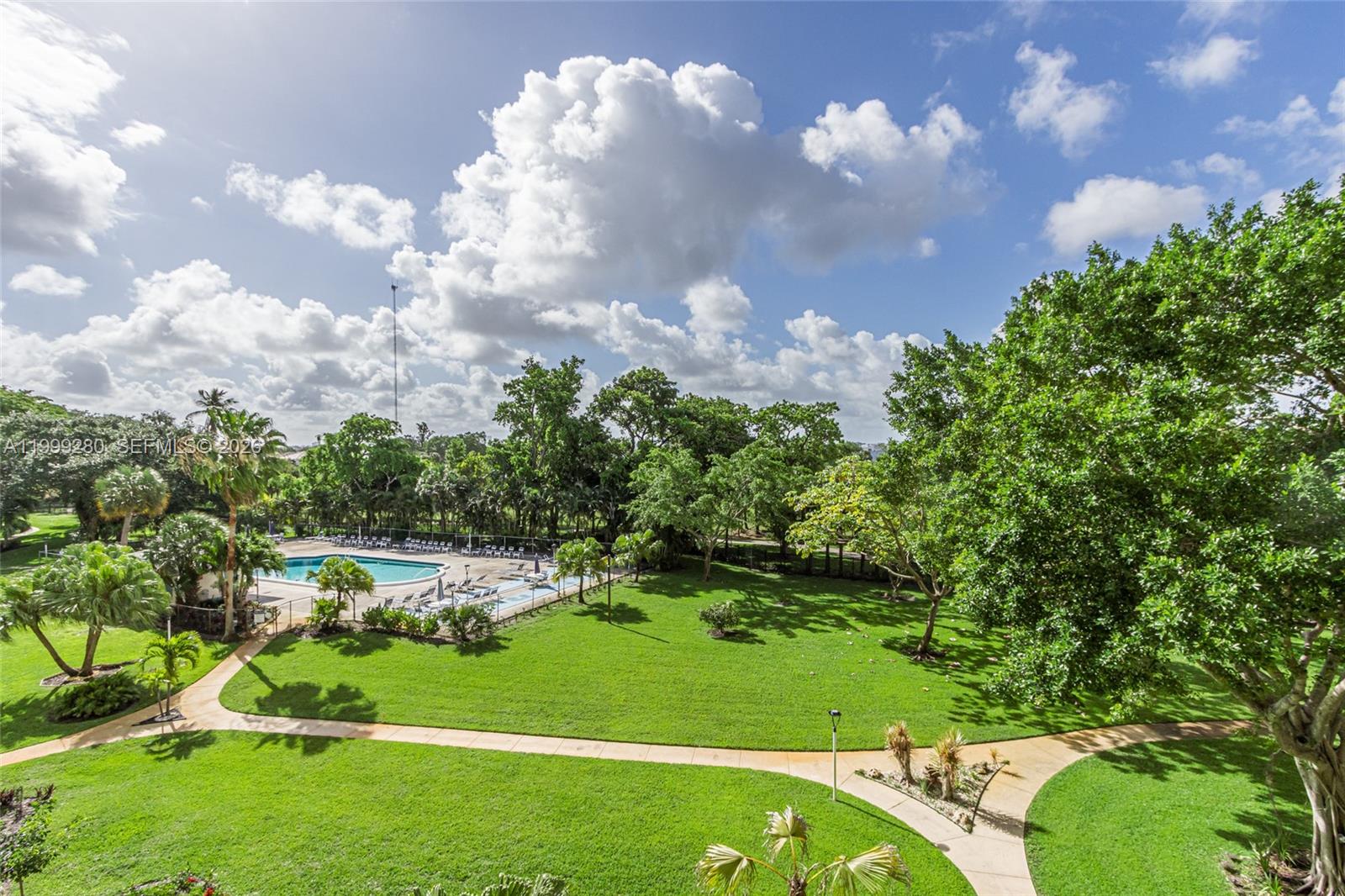 An elevated view shows a swimming pool, a large grassy lawn, and surrounding trees — 4330 Hillcrest Dr # 405, Hollywood FL 33021, HOLLYWOOD, FL