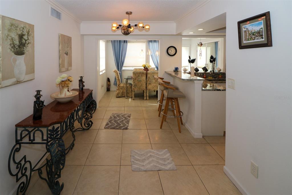 A tiled entryway leads to a dining area and a kitchen with a breakfast bar — 4158 TAMIAMI TRAIL UNIT G1, PORT CHARLOTTE, FL