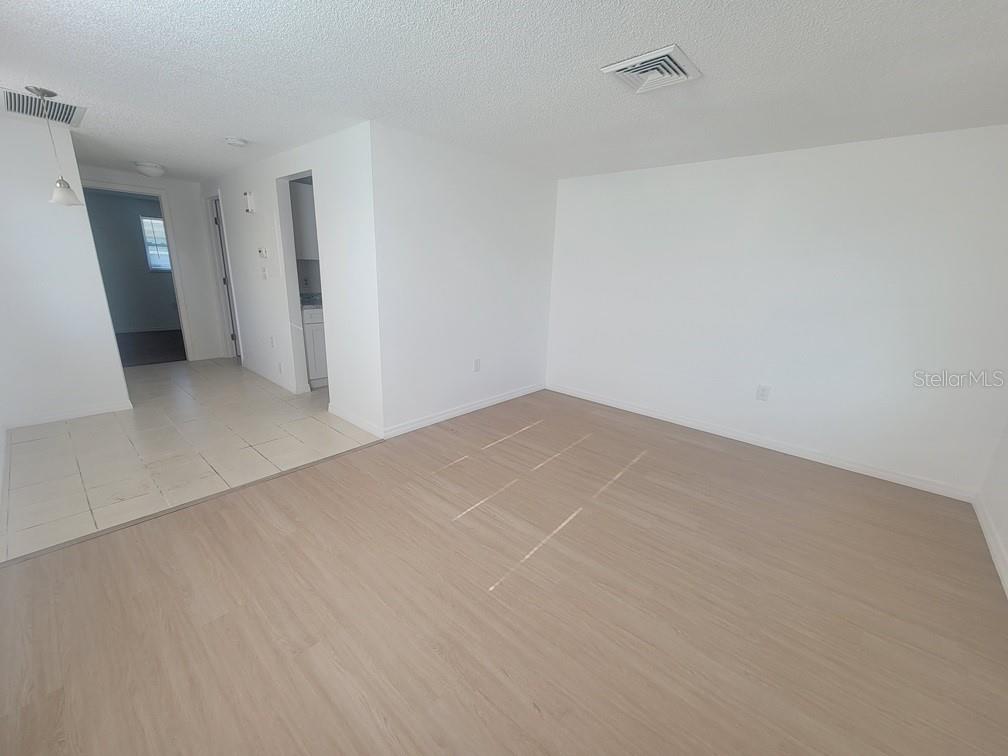 An interior view showing a living area with light wood flooring and a tiled entryway — 4922 FILNER STREET, NEW PORT RICHEY, FL