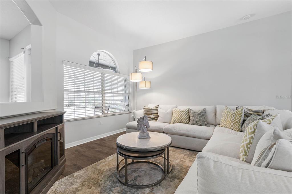 A living room features a white sectional sofa, a round coffee table, and a fireplace — 51 BANNERWOOD LANE, PALM COAST, FL