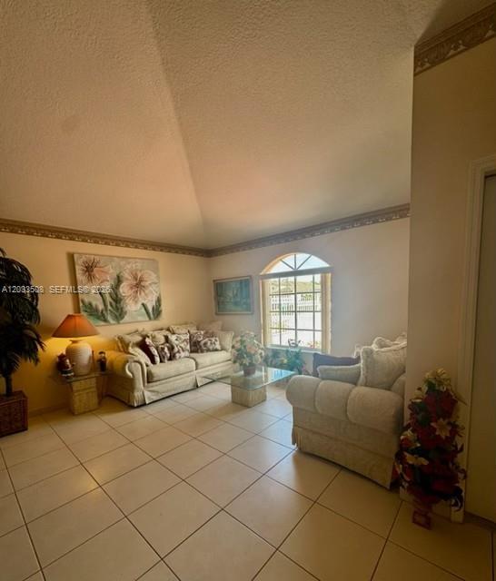A living room with vaulted ceilings, tile floors, a sofa, and a window with blinds — 14365 SW 172nd Ln, Miami FL 33177, MIAMI, FL