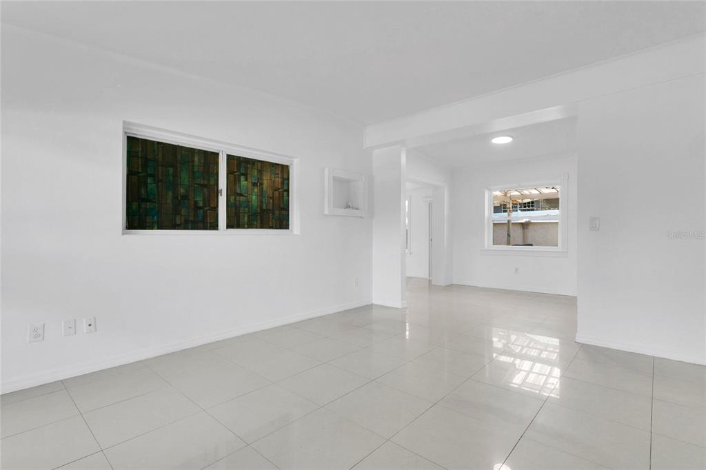 An empty room with white walls, light-colored tile flooring, and a window with stained glass — 5910 INDIAN HILL ROAD, ORLANDO, FL