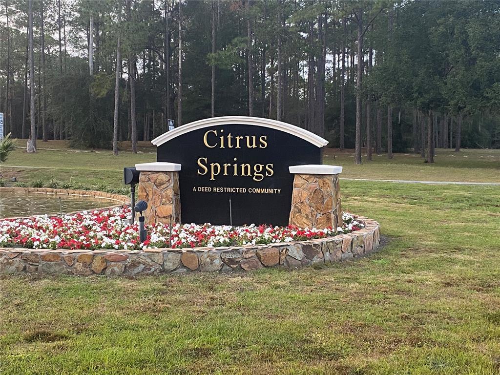A stone-based monument sign for Citrus Springs sits in a landscaped bed with flowers — 8282 N BROOK WAY, CITRUS SPRINGS, FL