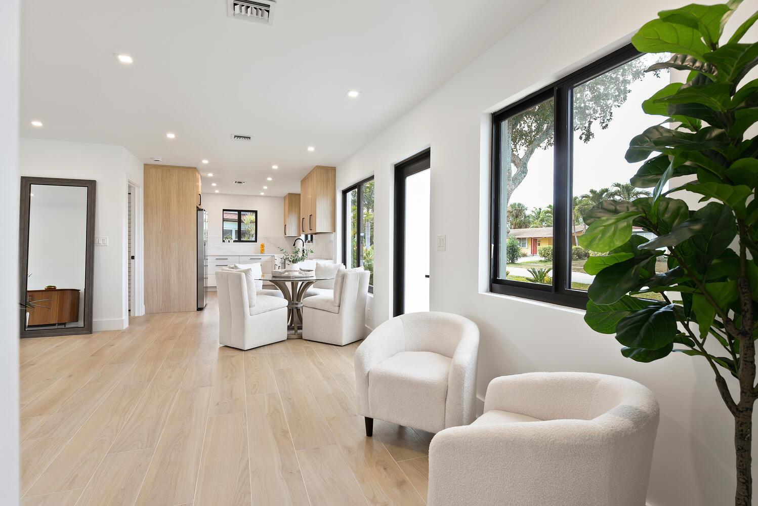 A bright, modern living area with light wood floors, white walls, and a dining nook — 1320 S Deerfield Avenue, Deerfield Beach FL 33441, DEERFIELD BEACH, FL
