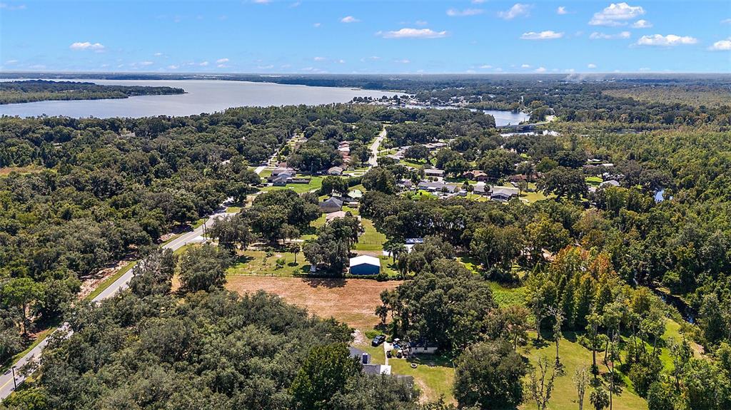 An aerial view shows a rural residential area with houses, trees, and a large lake — LAKE UNITY ROAD, FRUITLAND PARK, FL