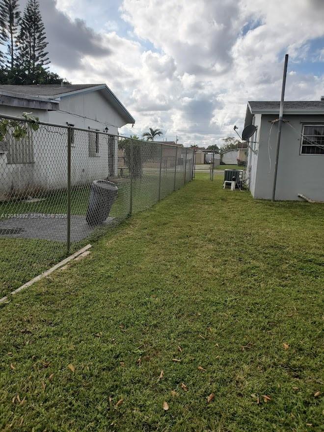 A grassy side yard separates two houses divided by a chain-link fence — 14721 SW 104th Ave, Miami FL 33176, MIAMI, FL