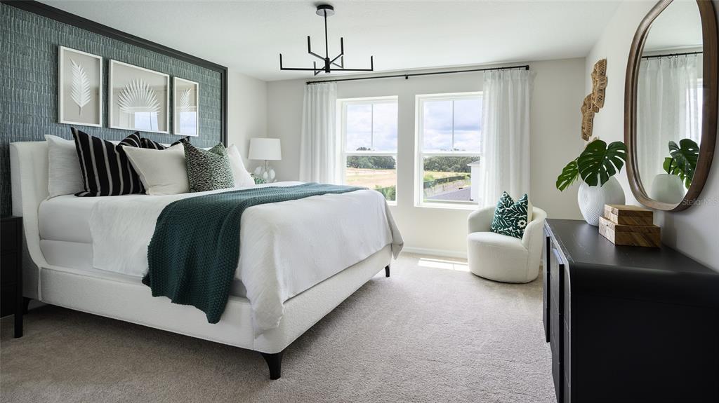 A bedroom features a white bed, dark accent wall, two windows, and a black dresser — 1577 SAGE AVENUE, HAINES CITY, FL