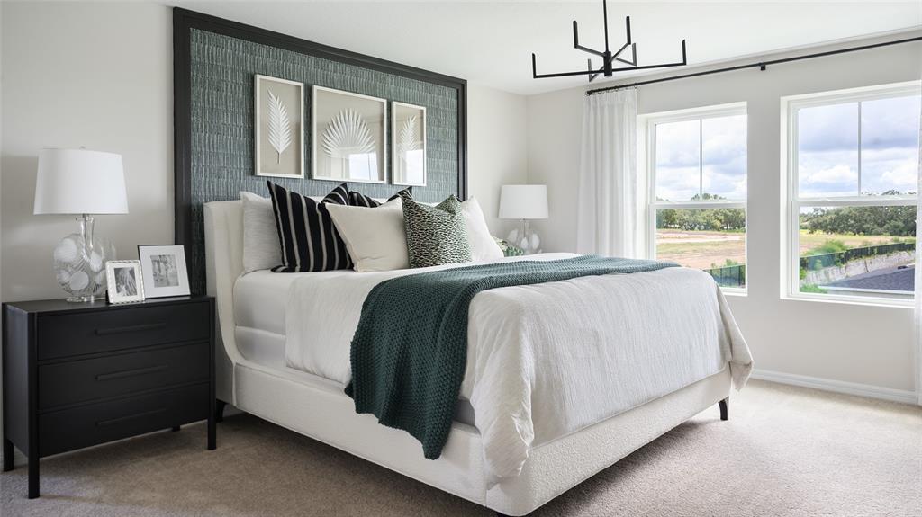 A bedroom features a white upholstered bed, dark nightstand, and a textured green accent wall — 1577 SAGE AVENUE, HAINES CITY, FL