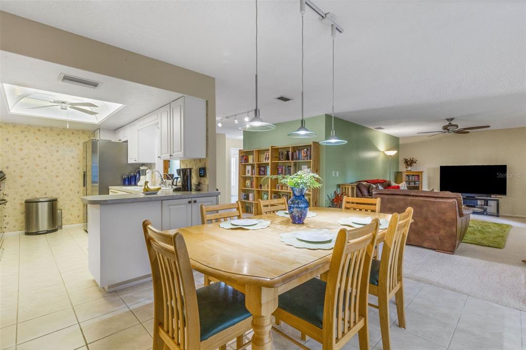 A dining area with a wooden table and chairs sits adjacent to a kitchen — 1518 70TH STREET W, BRADENTON, FL