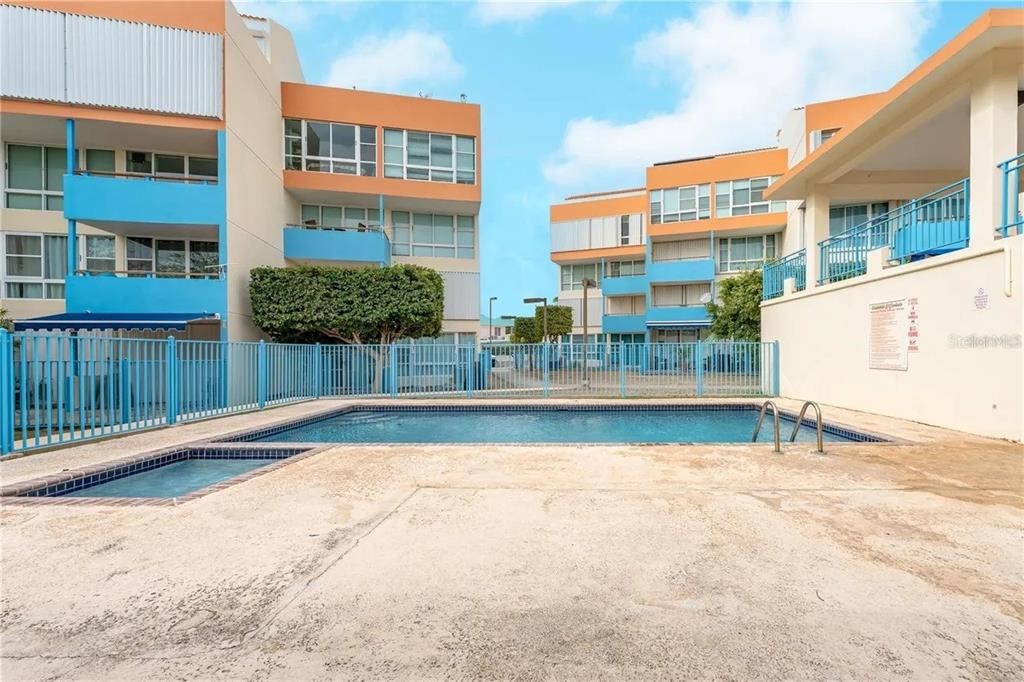 An outdoor swimming pool and hot tub are situated between two multi-story apartment buildings — PR-301 CONDO. VISTAMAR EL COMBATE UNIT B-207, CABO ROJO, PR