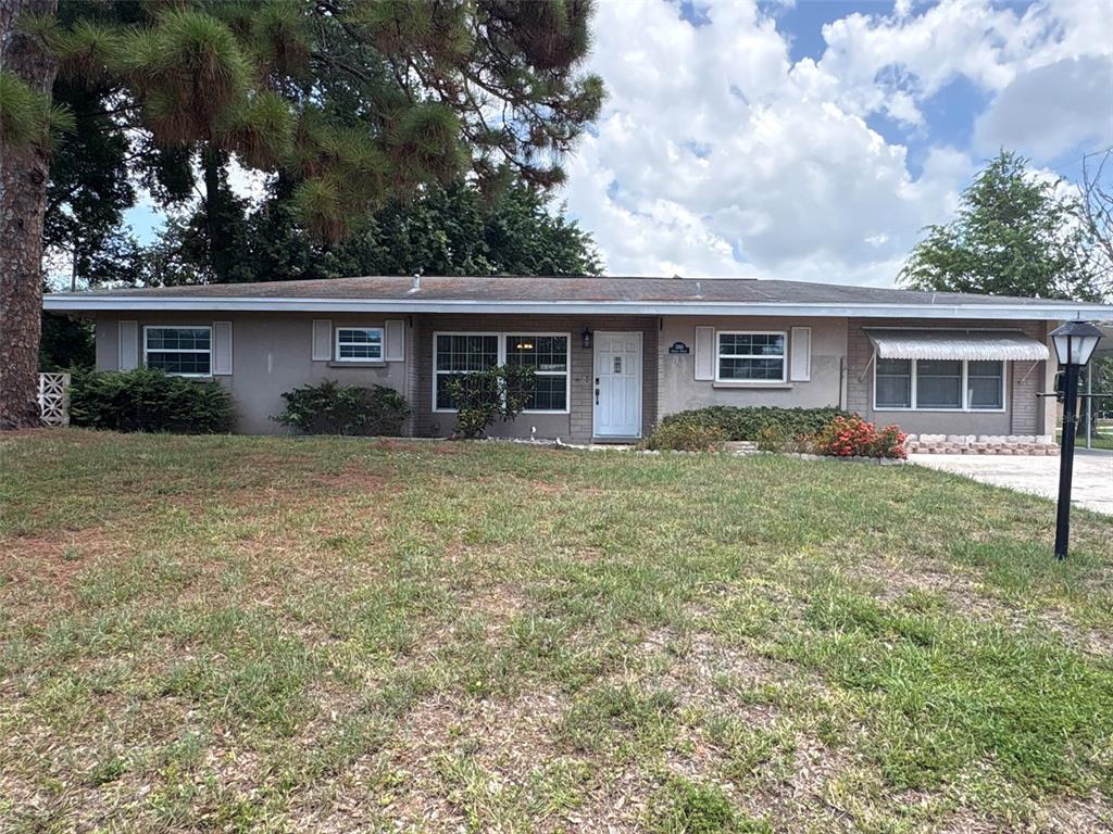 A single-story house with a gray exterior, a white front door, and a grassy lawn — 3341 ANDREA STREET, SARASOTA, FL