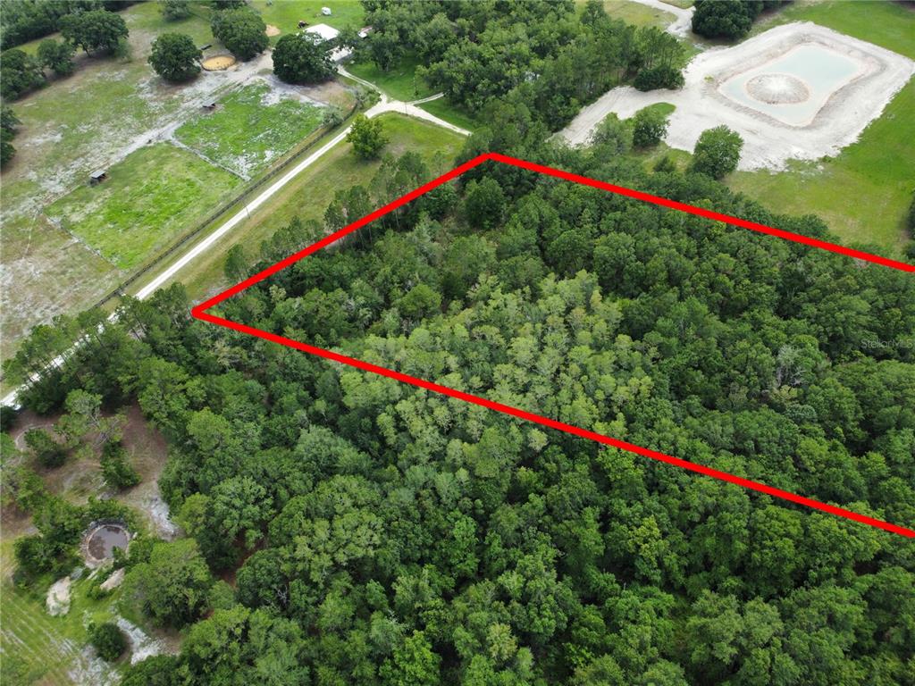 An aerial view shows a wooded plot of land outlined in red — TBD SE 136TH STREET, STARKE, FL