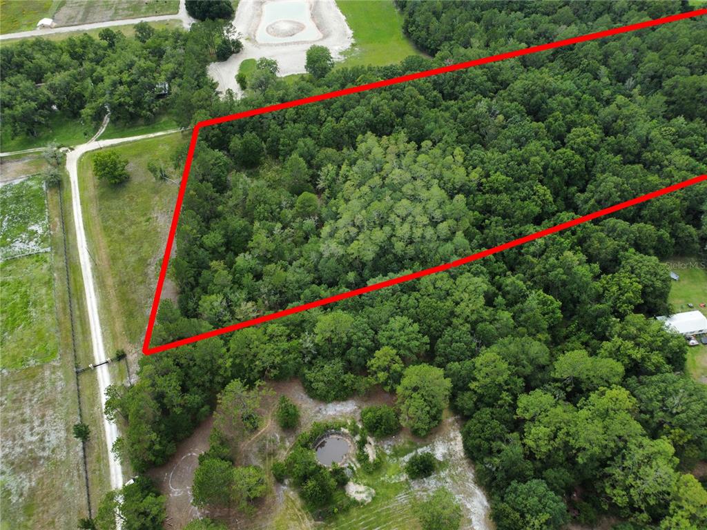 An aerial view shows a wooded plot of land outlined in red — TBD SE 136TH STREET, STARKE, FL