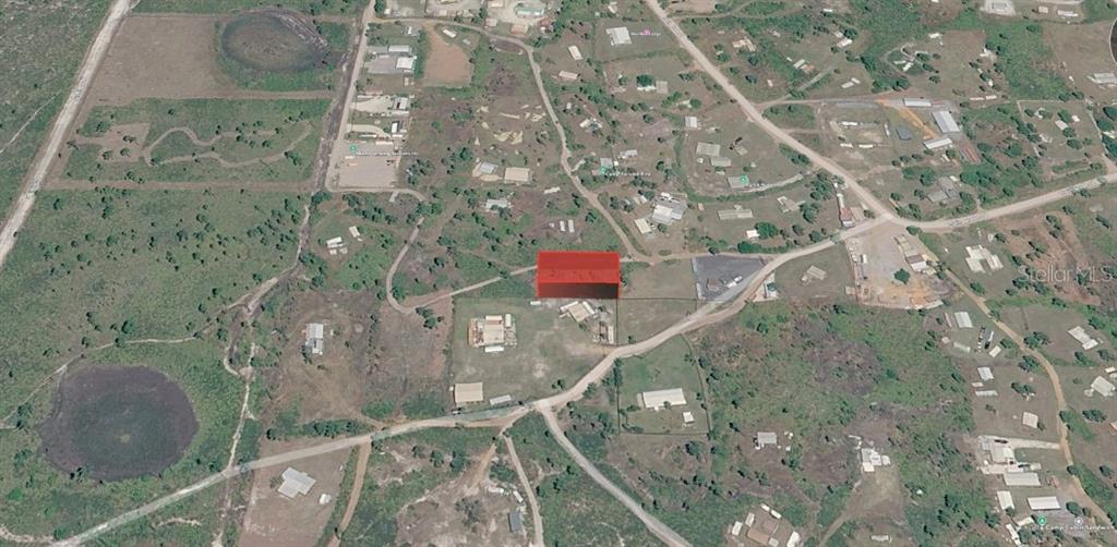 An aerial view shows a rectangular plot of land highlighted in red within a rural area — UNNASSIGNED, FROSTPROOF, FL