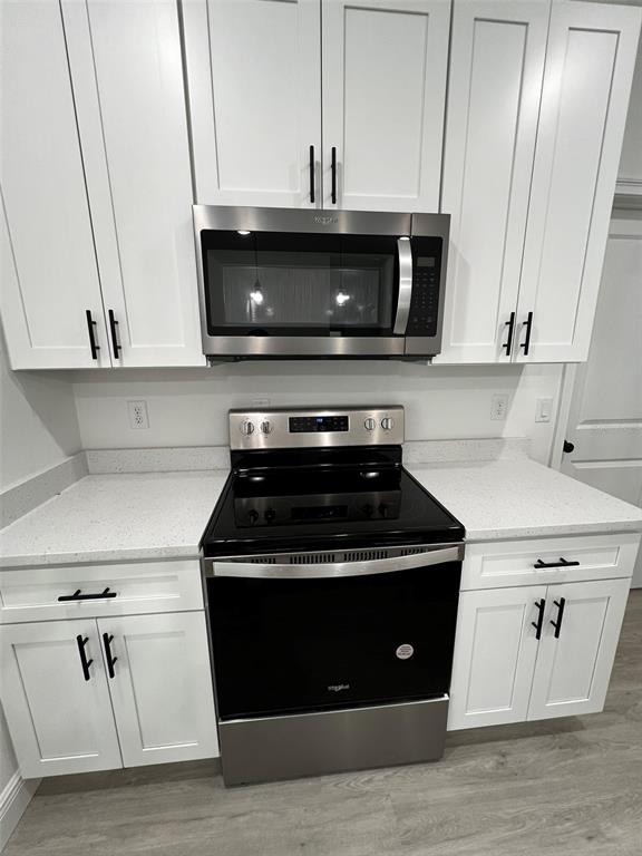 A kitchen features white cabinets, stainless steel appliances, and light-colored countertops — 3 FISHER PLACE DRIVE, OCKLAWAHA, FL