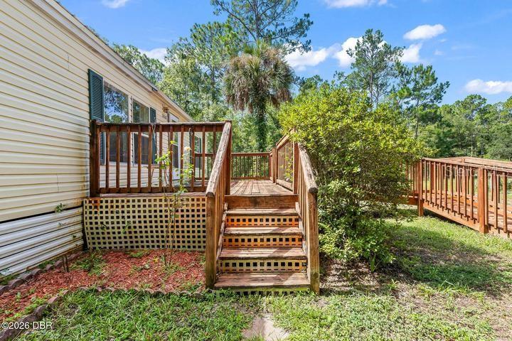 A wooden deck with stairs and a ramp attached to the side of a house — 10120 OLIVER AVENUE, HASTINGS, FL