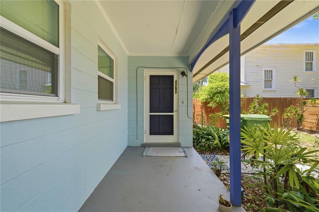 A light blue house features a covered front porch with a dark blue support post — 1751 6TH STREET, SARASOTA, FL