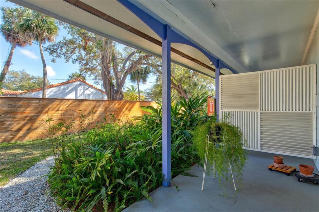 A covered patio features a concrete floor, blue support beams, and a white privacy screen — 1751 6TH STREET, SARASOTA, FL