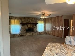 A living room features a stone fireplace, wood-paneled walls, and a ceiling fan — 2066 KATIE COURT, WINTER HAVEN, FL