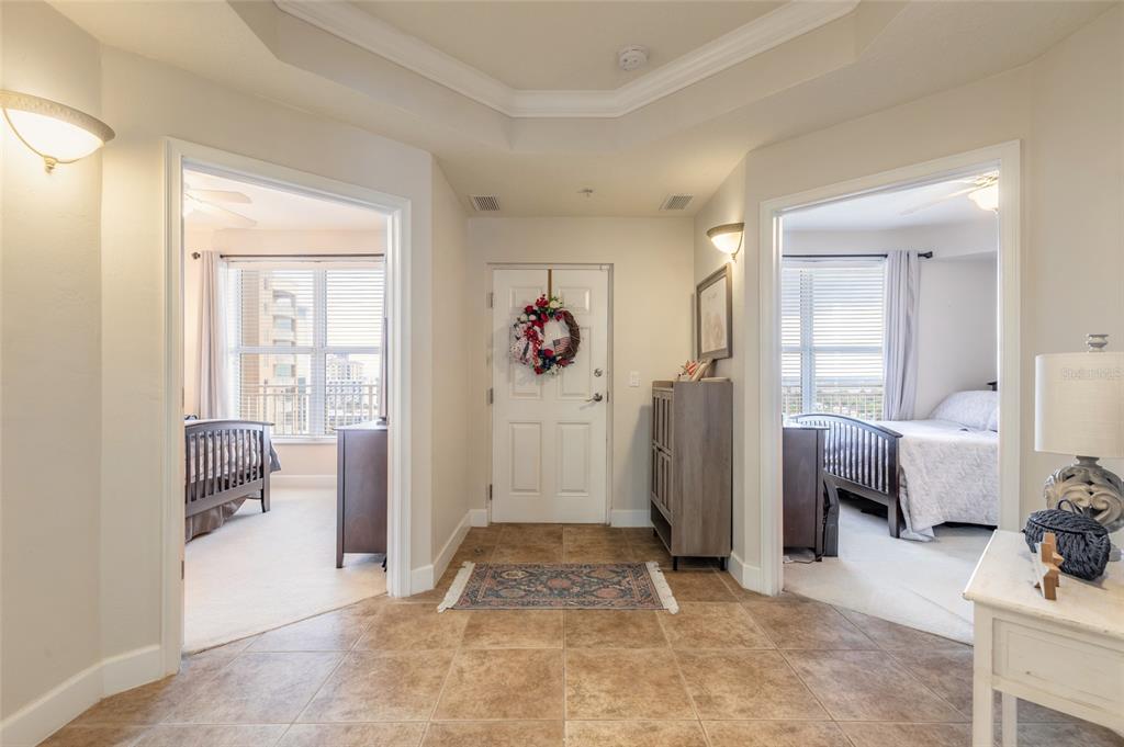 A tiled entryway leads to a front door flanked by two bedrooms with carpeted floors — 2403 S ATLANTIC AVENUE UNIT 910, DAYTONA BEACH SHORES, FL