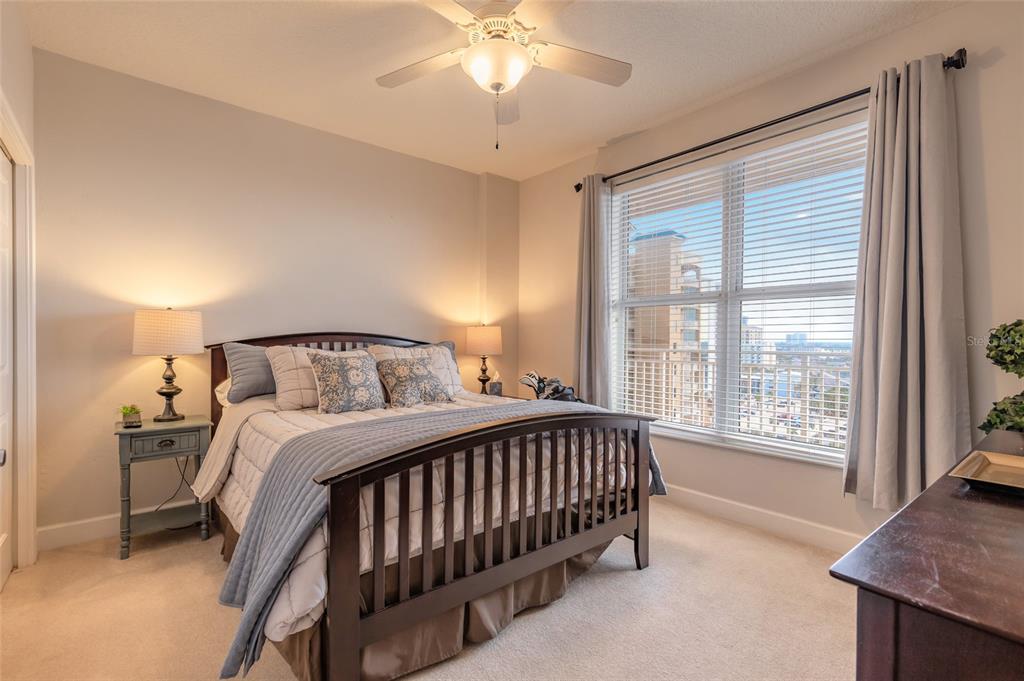 A bedroom features a queen bed, two nightstands, a ceiling fan, and a large window — 2403 S ATLANTIC AVENUE UNIT 910, DAYTONA BEACH SHORES, FL