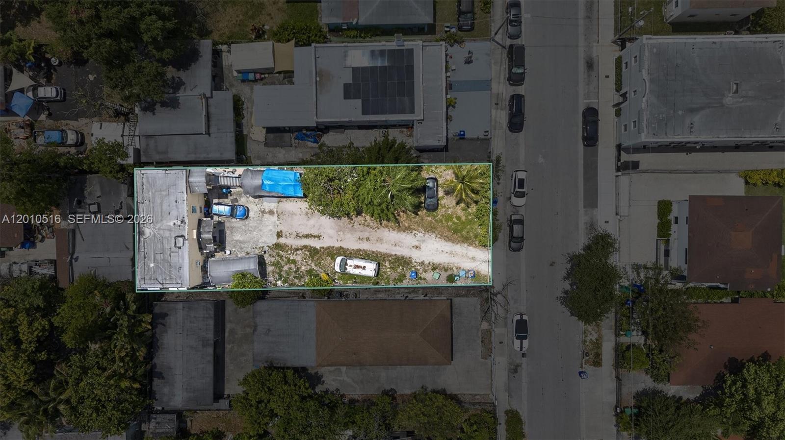 An aerial view shows a rectangular lot with a building, gravel driveway, and several vehicles — 244 NW 32nd St, Miami FL 33127, MIAMI, FL