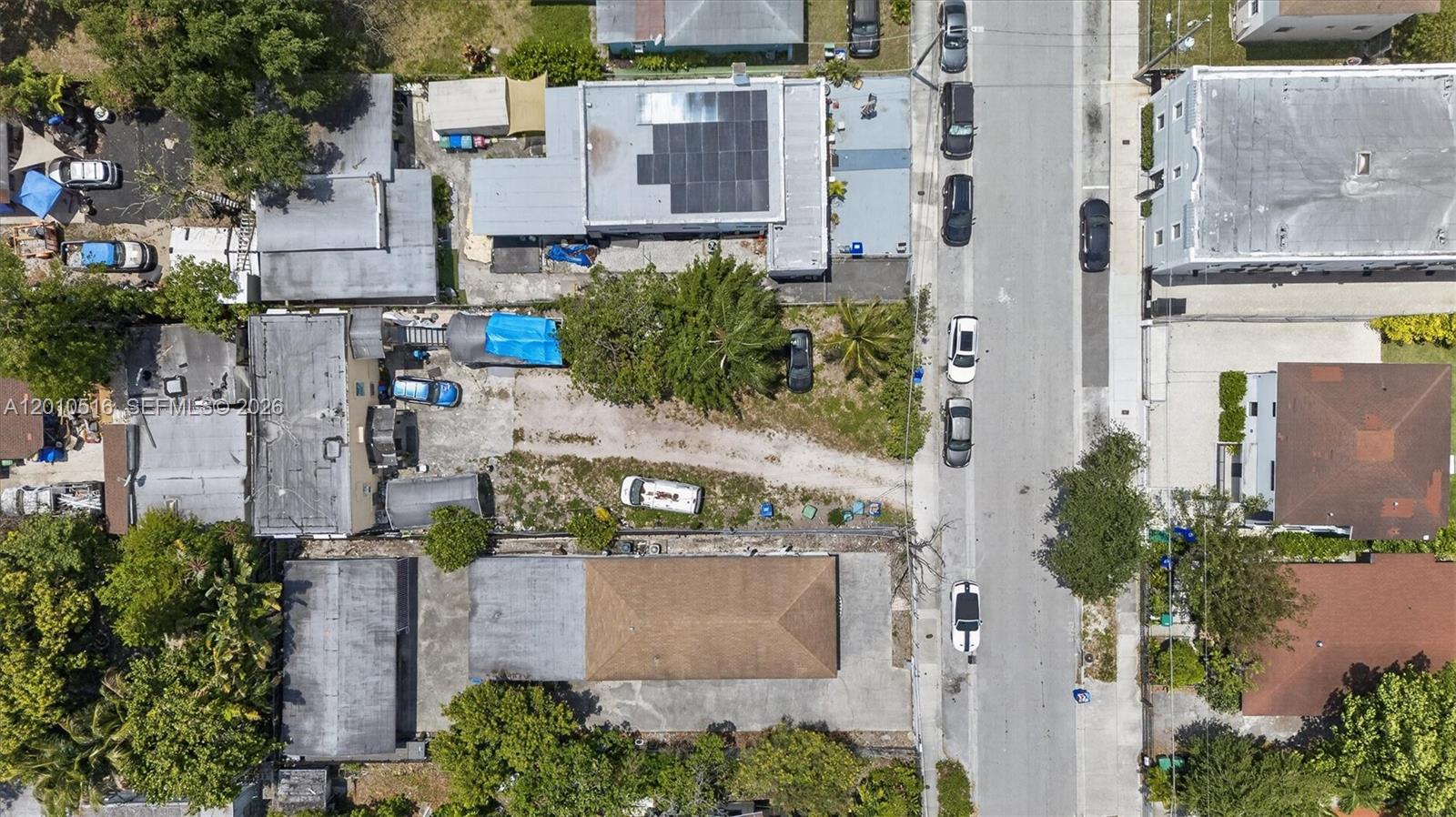 An aerial view shows several buildings, a gravel lot, and cars parked along a street — 244 NW 32nd St, Miami FL 33127, MIAMI, FL