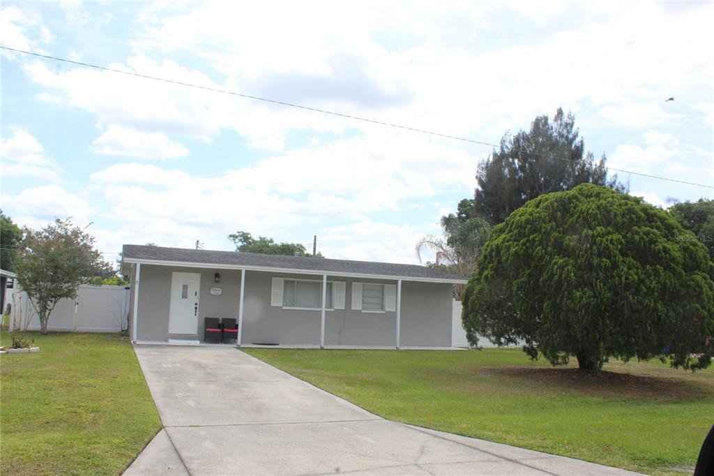A single-story gray house with a white front door and a concrete driveway — 307 CALIFORNIA AVENUE, ST CLOUD, FL