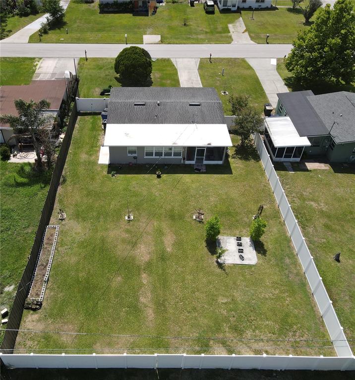 An aerial view shows a house with a large fenced backyard and a concrete patio — 307 CALIFORNIA AVENUE, ST CLOUD, FL