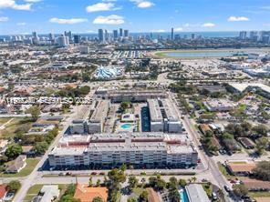 This aerial view shows a multi-story residential complex with a central pool near a city — 215 SE 3rd Ave # 101A, Hallandale Beach FL 33009, HALLANDALE BEACH, FL
