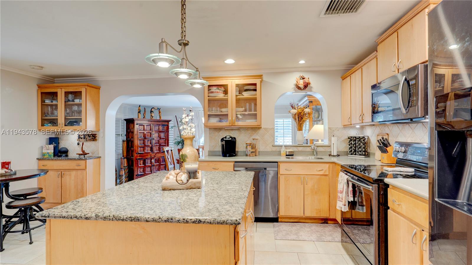 A kitchen features light wood cabinets, granite countertops, a central island, and stainless steel appliances — 150 Azalea St., Plantation Key FL 33070, PLANTATION KEY, FL