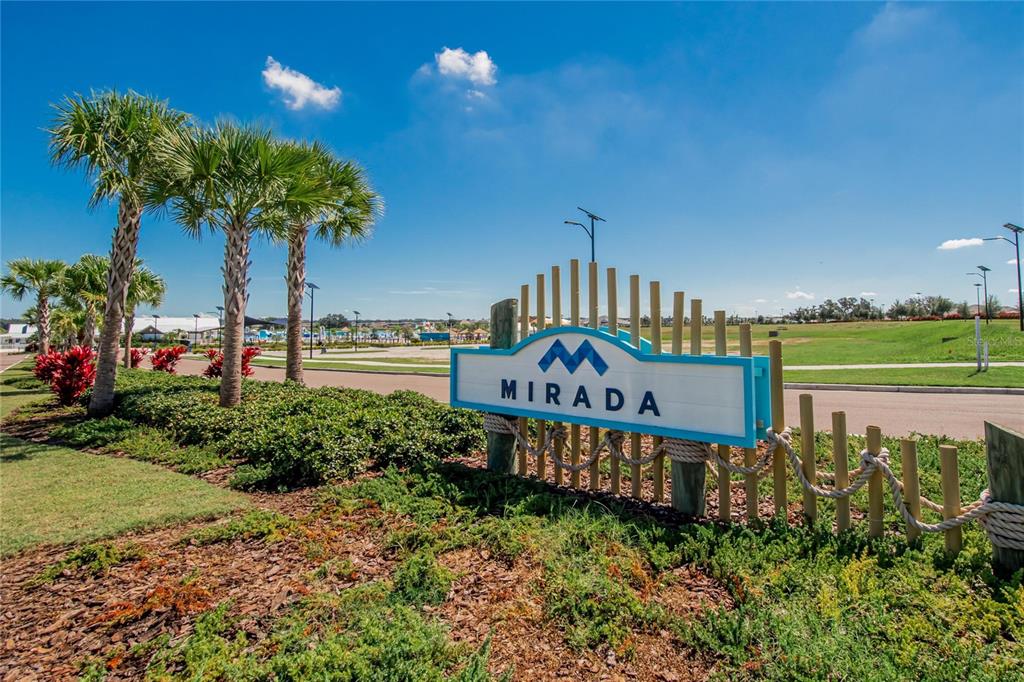 A sign for the Mirada community stands in a landscaped area with palm trees — 10009 SURREY ROSE DRIVE, SAN ANTONIO, FL