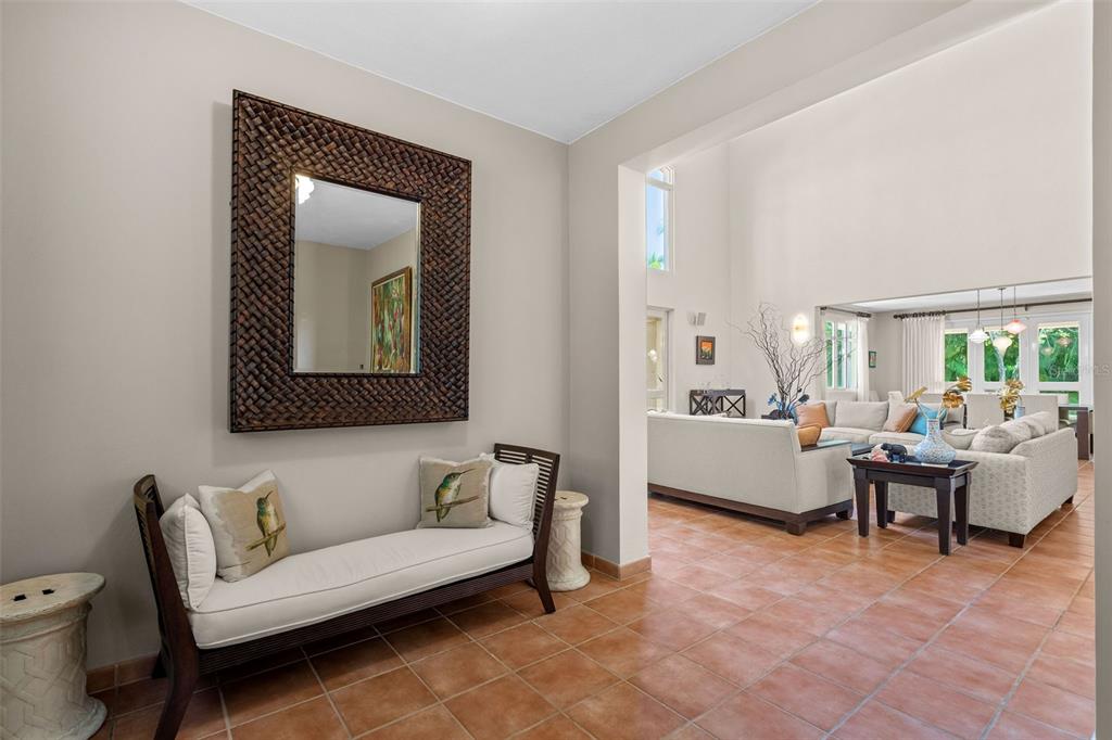 A foyer with a bench and mirror opens into a living room with tiled floors — 368 100 DORADO BEACH DRIVE, DORADO, PR