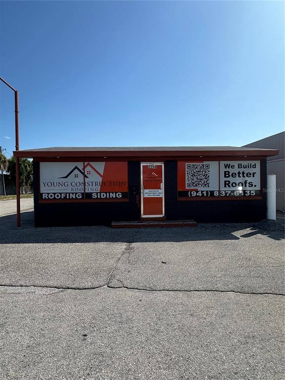 The exterior of a commercial building features orange signage for a roofing and siding company — 2254 S TAMIAMI TRAIL, VENICE, FL