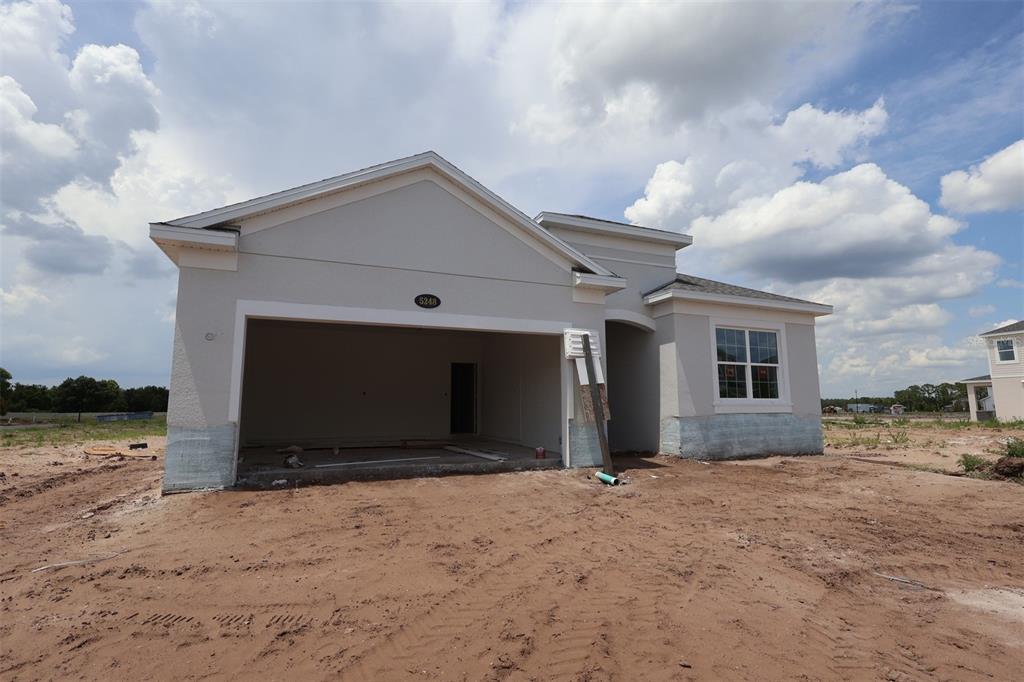 A kitchen under construction features light-colored cabinets, a central island with blue protective film, and unfinished flooring — 5248 HIGH LINE DRIVE, ST CLOUD, FL