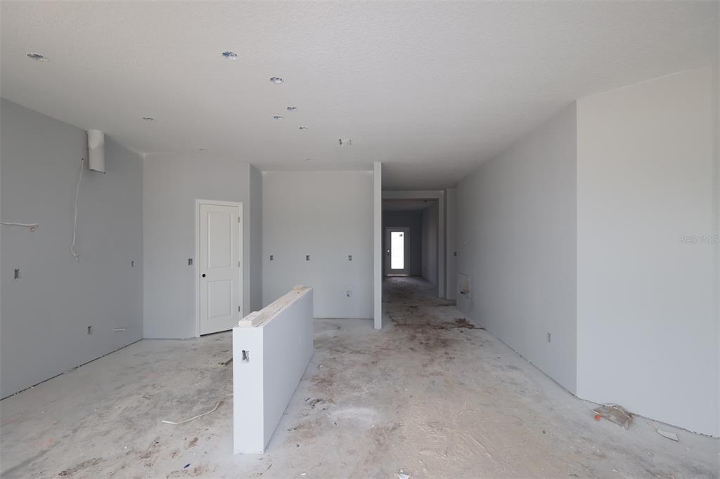An unfinished kitchen and living area with light-colored cabinets, a center island, and floor protection — 5248 HIGH LINE DRIVE, ST CLOUD, FL