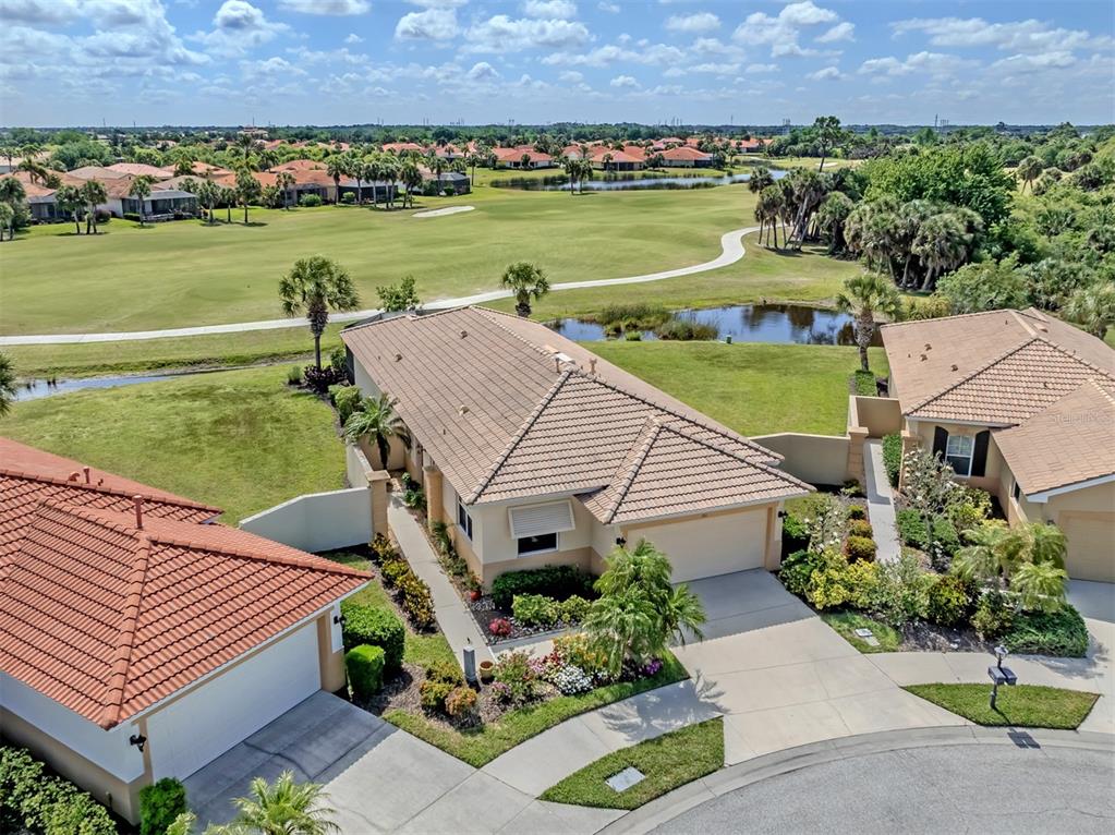 An aerial view shows a suburban house with a tile roof overlooking a golf course — 101 MESTRE PLACE, NORTH VENICE, FL