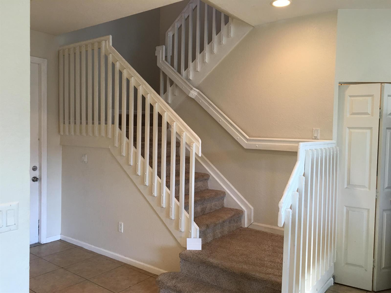 A carpeted staircase with white railings and trim in a neutral-toned residential interior — 1213 Abaco Lane, West Palm Beach FL 33404, WEST PALM BEACH, FL