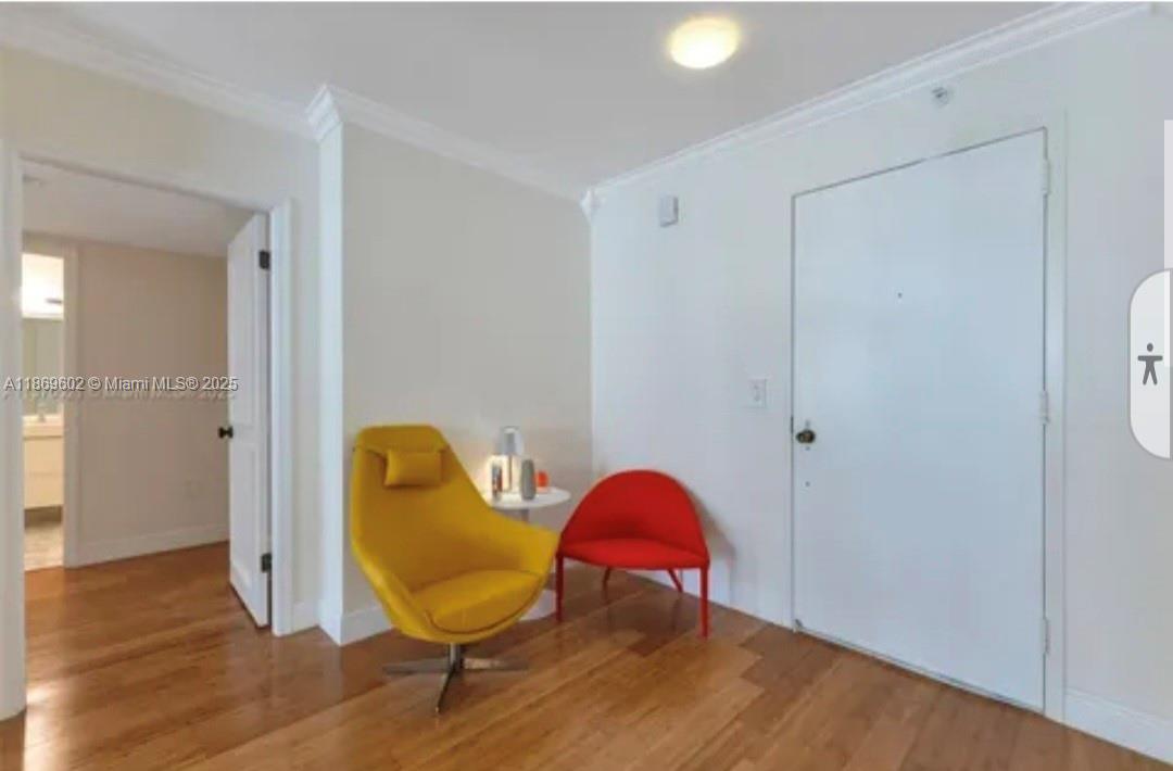 An interior room features hardwood floors, a yellow armchair, a red chair, and a door — 9801 Collins Ave # 10T, Bal Harbour FL 33154, BAL HARBOUR, FL