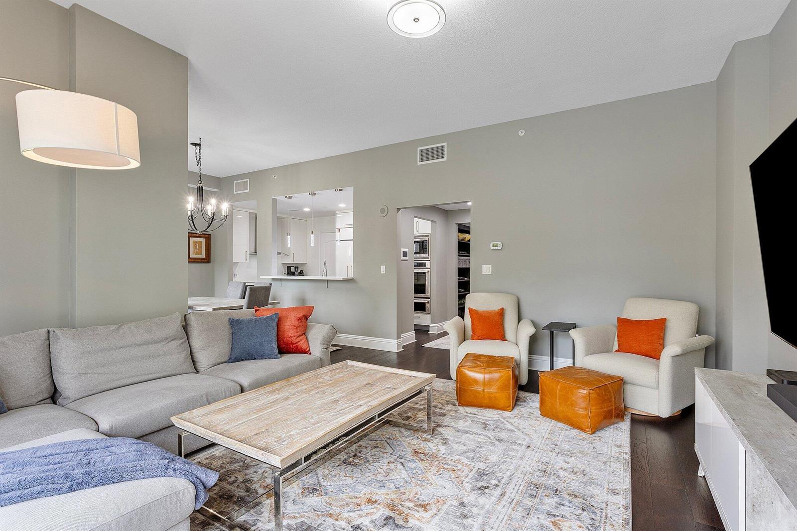 A living room features a grey sectional sofa, two armchairs with orange pillows, and ottomans — 200 E Palmetto Park Road # 10, Boca Raton FL 33432, BOCA RATON, FL