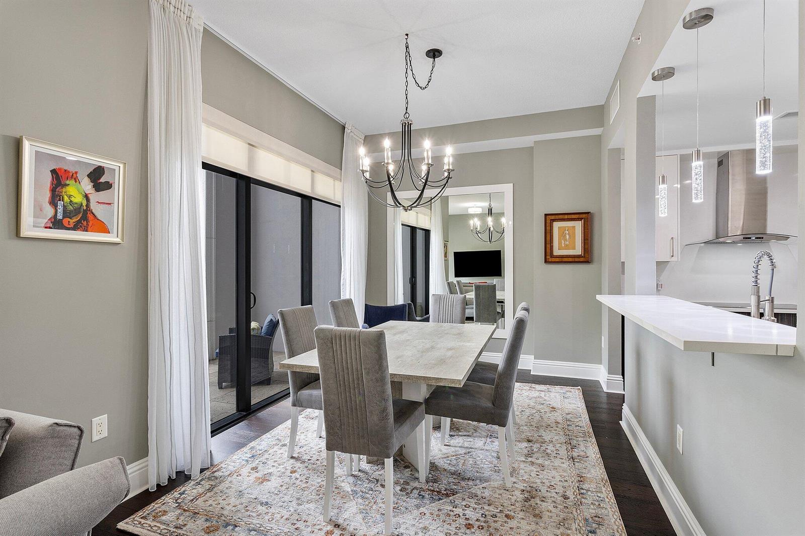 A dining room features a rectangular table, six gray chairs, a chandelier, and a rug — 200 E Palmetto Park Road # 10, Boca Raton FL 33432, BOCA RATON, FL